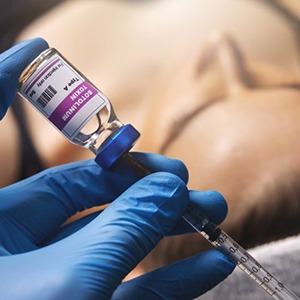 Gloved hand preparing BOTOX injection